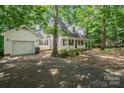 Well-maintained home with attached garage and long driveway surrounded by mature trees at 203 Hickory Wood Dr, Kannapolis, NC 28083