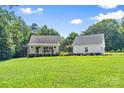 Daytime view of a home featuring a welcoming front porch and a detached garage at 220 Plonk Rd, Dallas, NC 28034