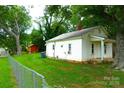 Exterior side view of home showcasing the spacious, green lawn, chain link fence, and cozy architecture at 238 Deaton St, Statesville, NC 28677