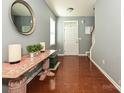 Bright foyer with hardwood floors, a decorative table, and a view of the staircase at 3009 Canopy Dr, Indian Trail, NC 28079