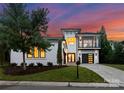 Stunning modern home with black framed windows, a balcony and black garage doors, surrounded by a lush lawn at 3308 Carmel Rd, Charlotte, NC 28226