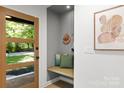 Bright entryway with a wooden door, bench seating, and decorative art at 3519 Campbell Dr, Charlotte, NC 28205