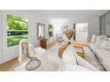 Bright living room with hardwood floors, white furniture, and large windows at 3519 Campbell Dr, Charlotte, NC 28205
