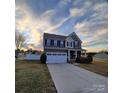 Two-story home with a two-car garage, neutral siding, black shutters, and a covered front porch at 3717 English Garden Dr, Gastonia, NC 28056