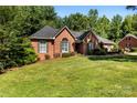 A beautiful brick house with a well-maintained lawn surrounded by lush green trees at 600 Queens Rd, Cherryville, NC 28021
