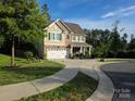 Beautiful home with stone accents, complemented by lush landscaping and a spacious driveway with an attached garage at 6412 Bluegill Rd, Charlotte, NC 28216