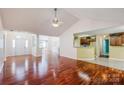 Open-concept living space featuring hardwood floors, vaulted ceiling, and views into the kitchen at 6414 Goldenblush Cir, Charlotte, NC 28269