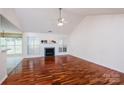 Bright living room with hardwood floors, fireplace, and vaulted ceiling with a ceiling fan at 6414 Goldenblush Cir, Charlotte, NC 28269