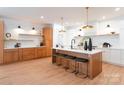 Spacious modern kitchen features an island with seating, stylish lighting, and stainless steel appliances at 6711 Creft Cir, Lake Park, NC 28079