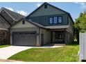 Rear exterior showcasing a garage and outdoor area with manicured lawn and space for entertaining at 6711 Creft Cir, Lake Park, NC 28079