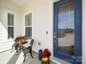Charming front porch with a cozy seating area and a stylish blue front door at 7150 Irongate Dr, Indian Land, SC 29707