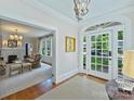 Inviting foyer featuring hardwood floors, an elegant chandelier, and arched doorway to the living room at 726 E Kingston Ave, Charlotte, NC 28203