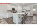 Bright kitchen featuring white cabinets, a center island with bar stools, and stainless steel appliances at 11139 Cardinal Creek Ave, Charlotte, NC 28215