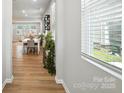 Bright hallway with wood floors, leading to a dining area with plenty of natural light at 11246 Bartrams Way, Charlotte, NC 28278