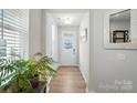 Bright foyer featuring wood floors, white trim, and a view of the front door with sidelights at 11246 Bartrams Way, Charlotte, NC 28278