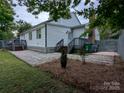 Backyard featuring a small deck with stairs, a gravel area, and green space at 11419 Leadenhall Ln, Charlotte, NC 28262