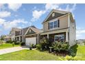 Landscaped front yard showcasing a charming two-story home with stone accents and inviting curb appeal at 1220 Kent Downs Sw Ave, Concord, NC 28027