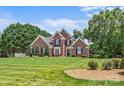 Beautiful brick home featuring lush green lawn, mature trees, and well-maintained landscaping at 1236 James Farm Rd, Hickory, NC 28602