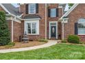 Close-up of the home's front entrance featuring a charming fountain, black door and manicured landscaping at 1236 James Farm Rd, Hickory, NC 28602