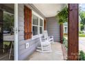 Cozy front porch showcases classic rocking chairs and verdant hanging plants, inviting relaxation at 1507 Breckenwood Dr, Rock Hill, SC 29732