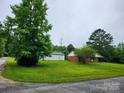 Well-maintained property with a detached garage, lush green lawn, and mature trees at 2448 Cambridge Dr, Lancaster, SC 29720