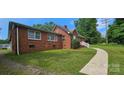 Side view of a brick home with a well-maintained lawn and inviting walkway at 2828 Bellhaven Cir, Charlotte, NC 28214