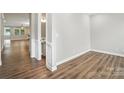 Hallway featuring hardwood floors with view to a half bath and a bright and open living space at 3029 Marchers Trace Dr, Charlotte, NC 28227
