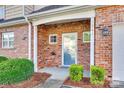 Inviting brick entryway with a storm door and manicured bushes at 349 Valley Brook Se Ln, Concord, NC 28025