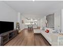 Open-concept living room featuring hardwood floors and modern décor at 517 Morrows Turnout Way, Pineville, NC 28134