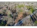 Aerial view featuring a plot of land nestled among trees and greenery in a residential neighborhood near a road at 531 Winding Way # 9, Belmont, NC 28012