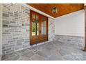 Close up of double wood front doors, stone floor, stone walls, and wood plank ceiling at 537 Riddle Mill Rd, Clover, SC 29710