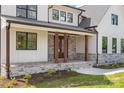 Inviting front porch with stone columns, wood accents, stone floor, and double front door at 537 Riddle Mill Rd, Clover, SC 29710