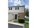 Exterior of home with black door, brick facade, tan vinyl siding, and green shrubs at base at 5941 Quail Hollow Rd # F, Charlotte, NC 28210
