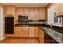 Bright kitchen with maple cabinetry, dark countertops, and stainless steel appliances at 6117 Yellowood Rd, Charlotte, NC 28210