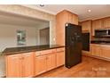Spacious kitchen featuring wood floors, ample cabinet space, and black appliances at 6117 Yellowood Rd, Charlotte, NC 28210