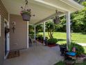 Relaxing covered patio with hanging plants and views of the beautiful green lawn at 725 Chelton Ln, Fort Mill, SC 29715