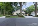 Well-maintained home featuring lush landscaping, a long driveway, and a detached garage at 802 E Franklin St, Monroe, NC 28112