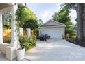 Spacious detached garage with a classic car parked in the driveway and a garden in the foreground at 802 E Franklin St, Monroe, NC 28112