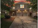 Charming home at sunset featuring a brick facade and a convenient two-car garage, perfect for modern living at 9428 Carneros Creek Rd, Charlotte, NC 28214
