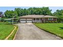 Charming brick home with a two-car garage, carport, and manicured lawn at 128 Howie St, Mount Holly, NC 28120