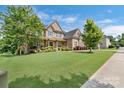 Charming brick home featuring a well-manicured lawn, landscaped garden and a covered front porch at 13519 Crystal Springs Dr # 148, Huntersville, NC 28078