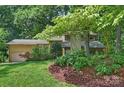 This exterior of a home is surrounded by lush trees with architectural details and landscaping at 1419 Jules Ct, Charlotte, NC 28226