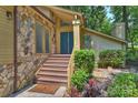 A welcoming entrance with a stone facade, steps leading to double doors, and manicured landscaping at 1419 Jules Ct, Charlotte, NC 28226