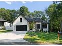 Beautiful white brick house with wooden columns, black framed windows, and manicured lawn at 1622 Burtonwood Cir, Charlotte, NC 28212