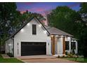 Inviting home exterior with a white brick facade, dark window trim, and a stylish covered front entrance at 1622 Burtonwood Cir, Charlotte, NC 28212