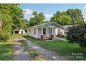 Well-maintained home with a long driveway and detached garage surrounded by mature trees at 1626 W Park Ave, Albemarle, NC 28001