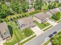 Aerial view showcasing the home, well-manicured lawn, mature trees, and neighborhood playground at 183 Canoe Pole Ln, Mooresville, NC 28117