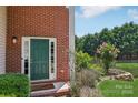 Inviting front entrance featuring a green door, brick facade, and manicured landscaping at 1986 Trace Creek Dr, Waxhaw, NC 28173