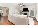 Cozy living room with fireplace, ceiling fan, hardwood floors, and neutral decor at 205 Rosedale Ln, Matthews, NC 28105