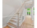 Bright foyer featuring elegant staircase with light wood treads and white risers and trim at 3011 Mckee Rd, Charlotte, NC 28270